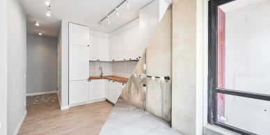 Partially renovated kitchen with exposed wall and cabinetry.