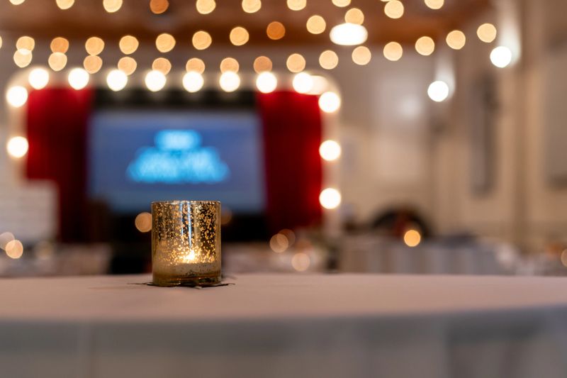 A candle cup on the table against a blurred background with bokeh lights at an event place