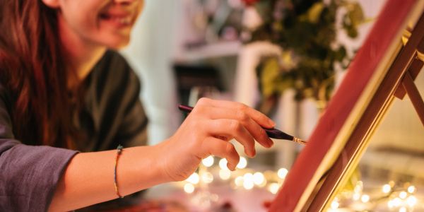 Person painting on a canvas with a brush.