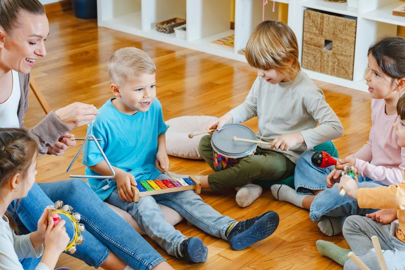 Teacher with children in a Kindergarten Classroom. Healthy learning environment. Kindergarten teacher, building relationships with the kids. Cheerful preschool children