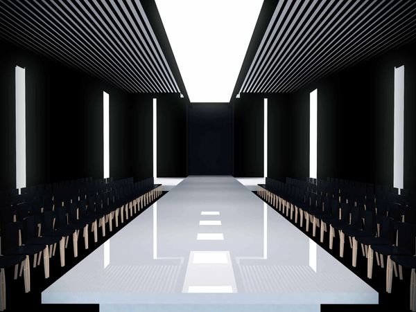 Sleek, modern fashion runway with dramatic lighting and black seating.