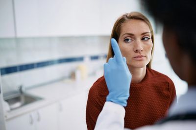 Doctor conducts eye exam with patient focusing on finger.