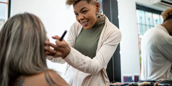 Makeup artist applying makeup on a client.