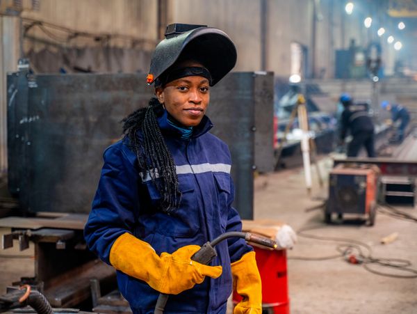 Welding activity with sparks and smoke near cardboard and tools outdoors.