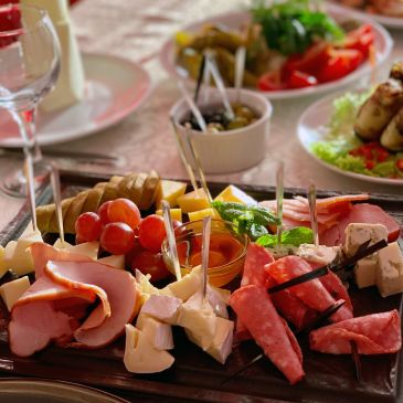 Charcuterie board with meats, cheeses, and fruit.