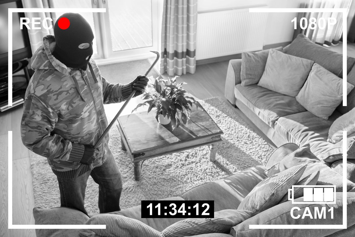 Masked intruder with crowbar caught on home security camera.