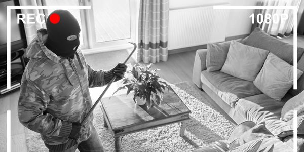 Masked intruder with crowbar caught on home security camera.