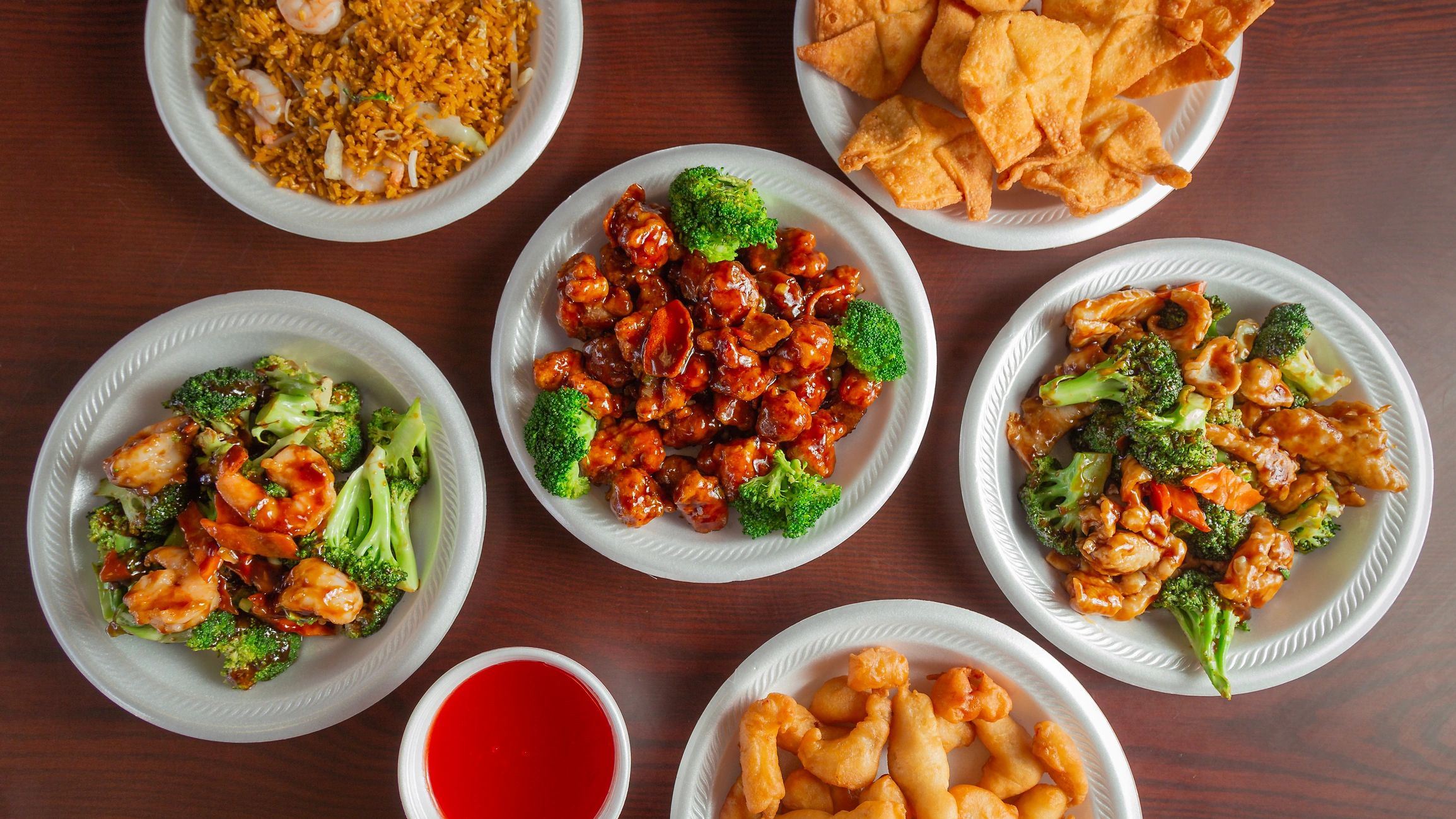 Variety of Chinese takeout food on white plates.