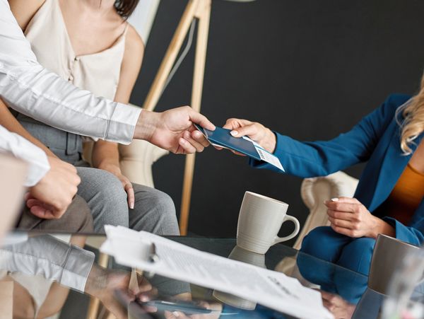 Couple handing over passports and boarding passes to a travel agent.