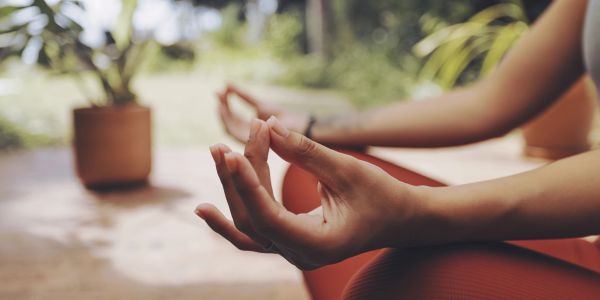 Person meditating with hands in mudra gesture.