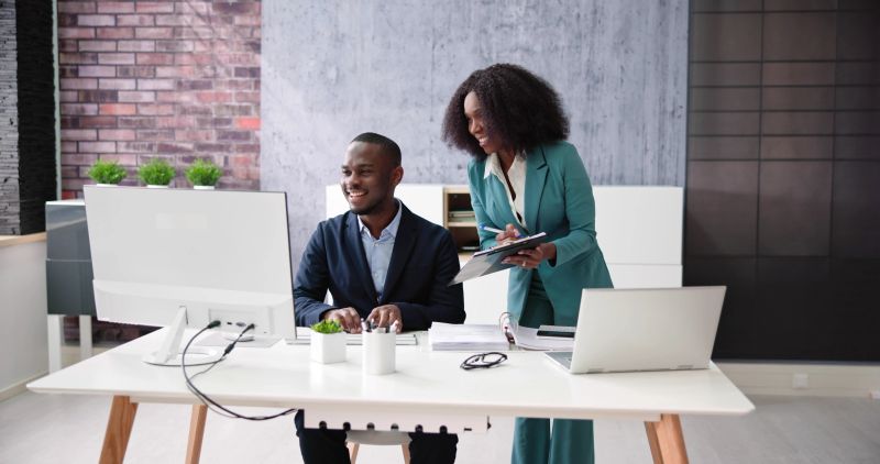 Computer Analyst Staff Training. Two African People At Desk