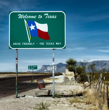 Urban cityscape with modern skyscrapers and a circular elevated walkway at dusk.