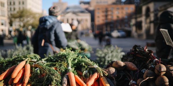 Fresh carrots and root vegetables at an outdoor market.