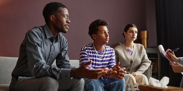 A family discussing with a therapist in a counseling session.