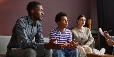 Three individuals engaged in a serious conversation.