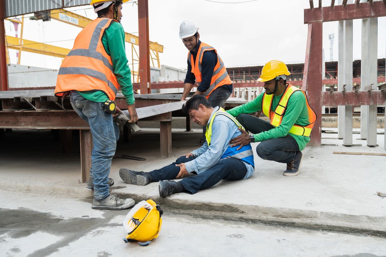 Construction workers assisting an injured colleague at a building site. employee benefits
insurance coverage
workers compensation insurance
