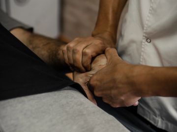 Therapist performing hand massage on a patient.