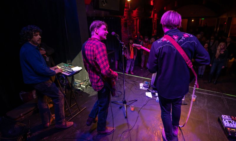 An Americana folk-rock band performing onstage in front of an audience at a live music venue.