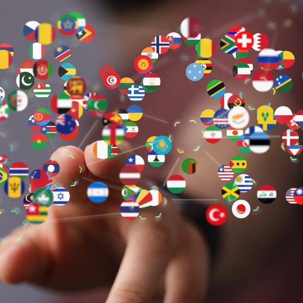 Finger pointing to a virtual screen with flags from many different countries.