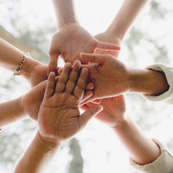 Multiple hands stacked together symbolizing unity and teamwork.