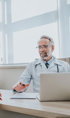 Healthcare worker holding an elderly patient's hands supportively.