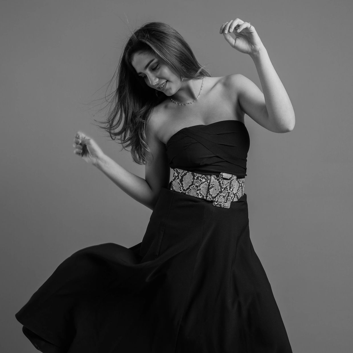 Woman dancing gracefully in a black dress.