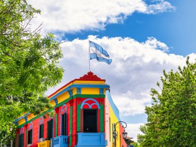 Casa colorida con bandera argentina en la azotea.