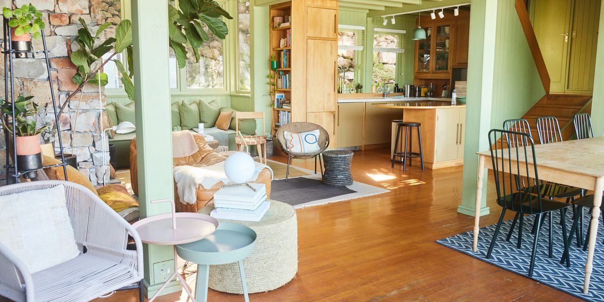 Bright, cozy living space with wooden floors, green walls, and stylish furniture.