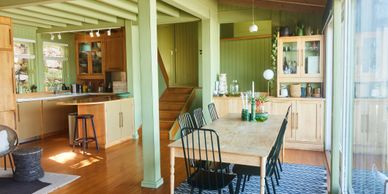 Bright dining area with wooden furniture and large windows.