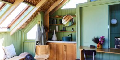 Cozy attic room with skylights and green walls.
