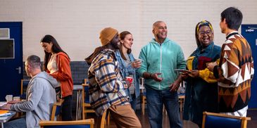 Group of diverse people socializing indoors.