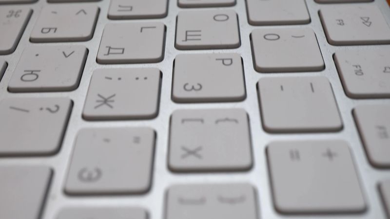 Wireless thin keyboard close -up. The keys are white. Camer slides approaching the object. Macro. 4k