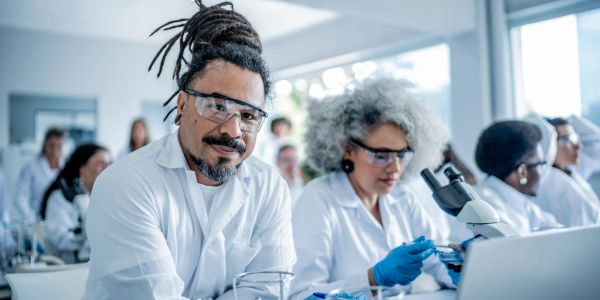 Scientists working in a lab with safety glasses and lab coats.