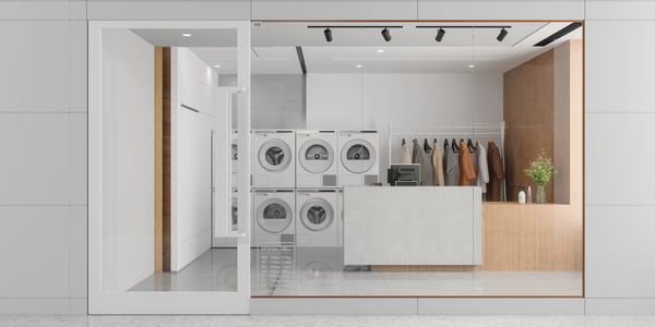 Modern, clean laundry shop with washing machines and clothing rack.