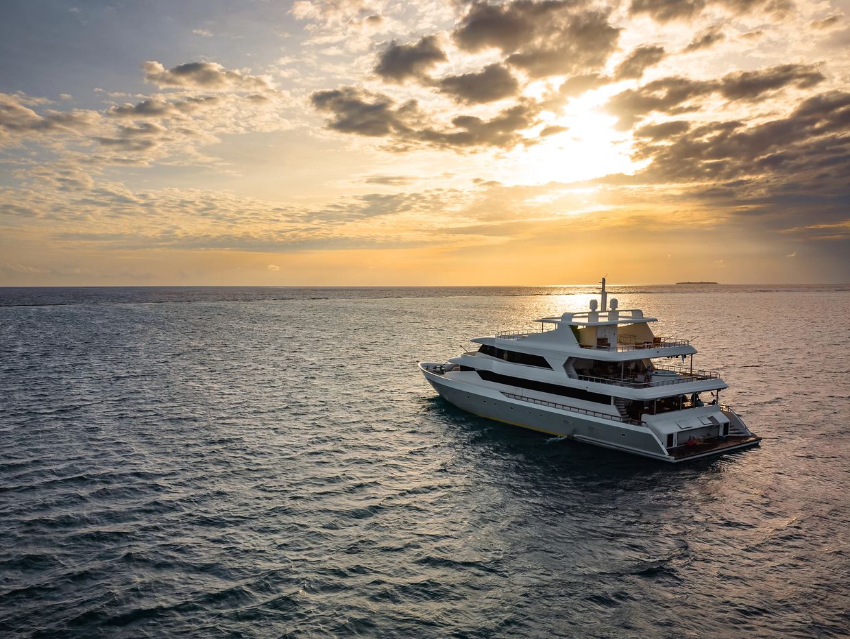 Luxury yacht sailing at sunset.