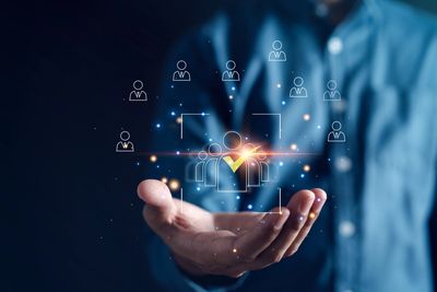 Hand holding digital icons representing selected people or team management.