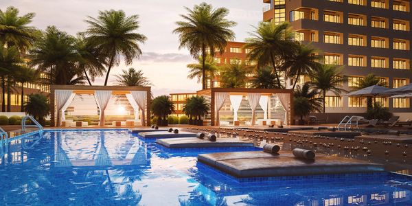 Luxurious pool area at sunset with cabanas and palm trees.