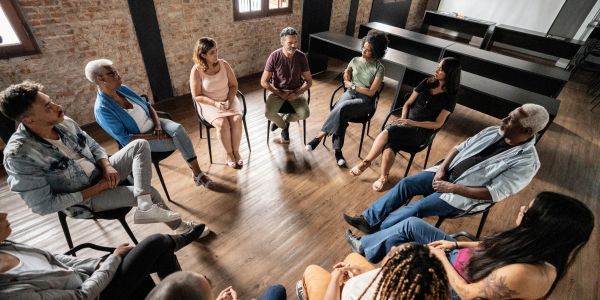 Diverse group in a therapy session sitting in a circle.