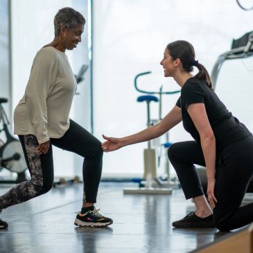 Senior woman exercising with instructor assistance.