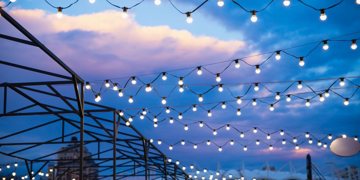 String lights glow against a twilight sky with clouds.