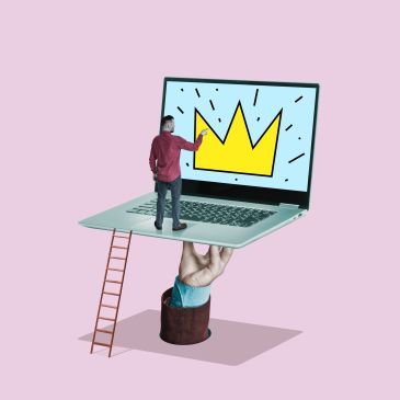 Man on laptop with a crown on the screen and hand holding the laptop.