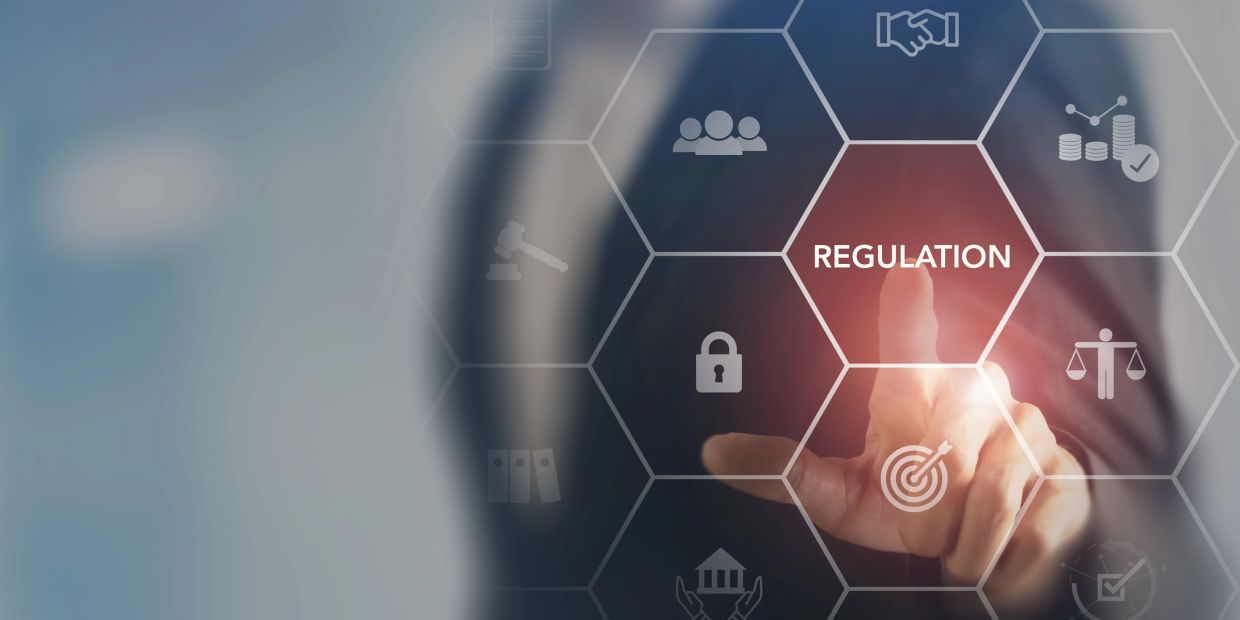 Person touching virtual regulation icon on hexagonal interface.