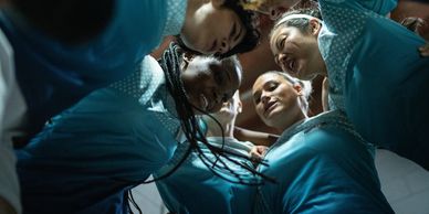Group of people in blue uniforms standing in a circle.