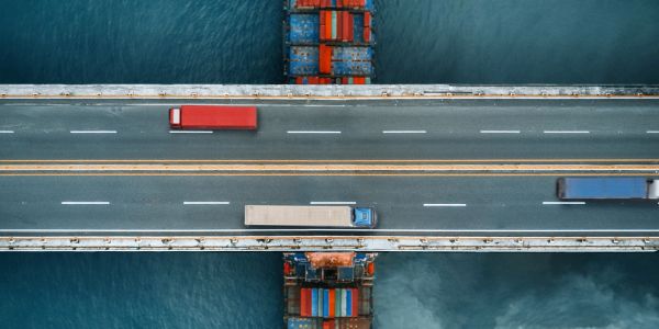 Trucks crossing a bridge over a waterway.