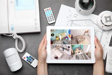 Person monitoring home security on a tablet.