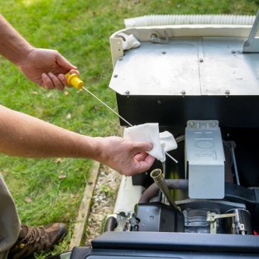 Checking the oil level of a generator outdoors.
