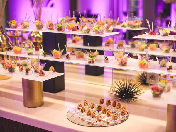 Elegant display of assorted appetizers in clear cups at an event.