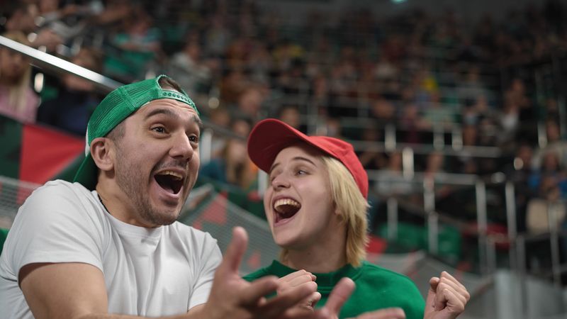 Football fans watch game match. Couple support favorite team. Crowd sport tribune. Soccer stadium stands. Victory goal score. Happy people rejoice win. Spectators enjoy view play. Girl guy joy scream.