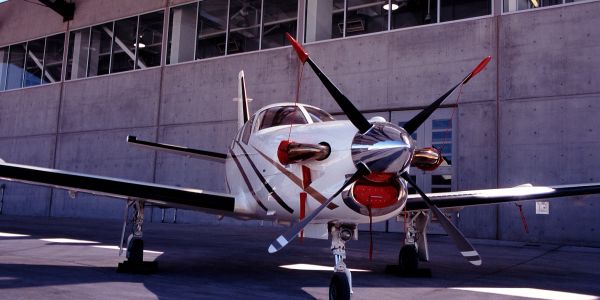 Small propeller airplane parked on tarmac.