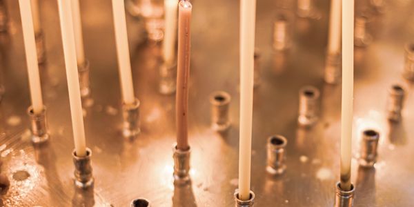 Burning candles in a metallic holder, creating a warm glow.